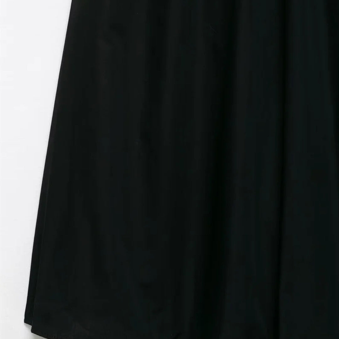 Svart midiklänning med smala axelband, markerad midja och dekorativt bälte