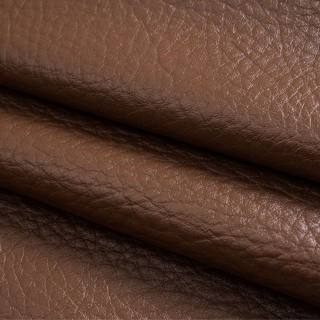 Brun kort kavajstil jacka i präglat veganskt läder med skulpturala ärmar och dekorativa guldfärgade knappar