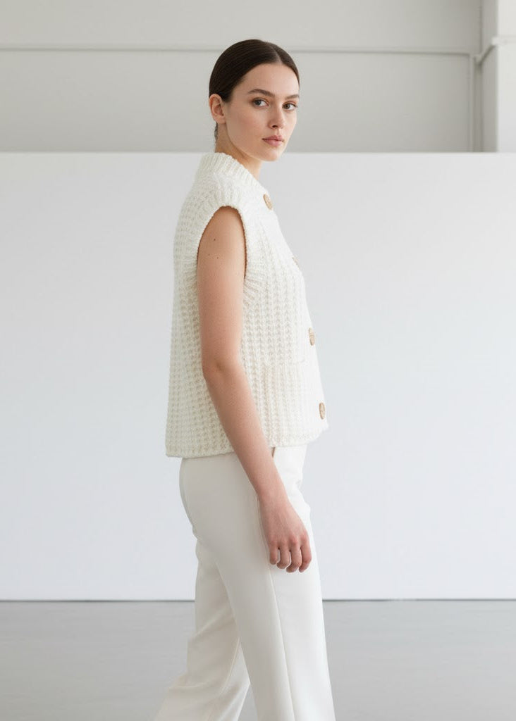 Tjockstickad ärmlös kofta med guldfärgade knappar