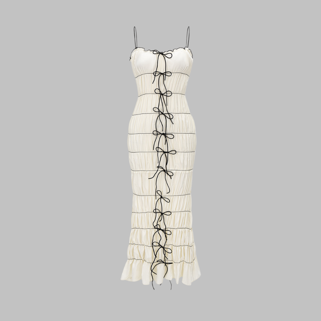 Midiklänning vit figurnära med smala axelband rynkad design och svarta rosetter fram