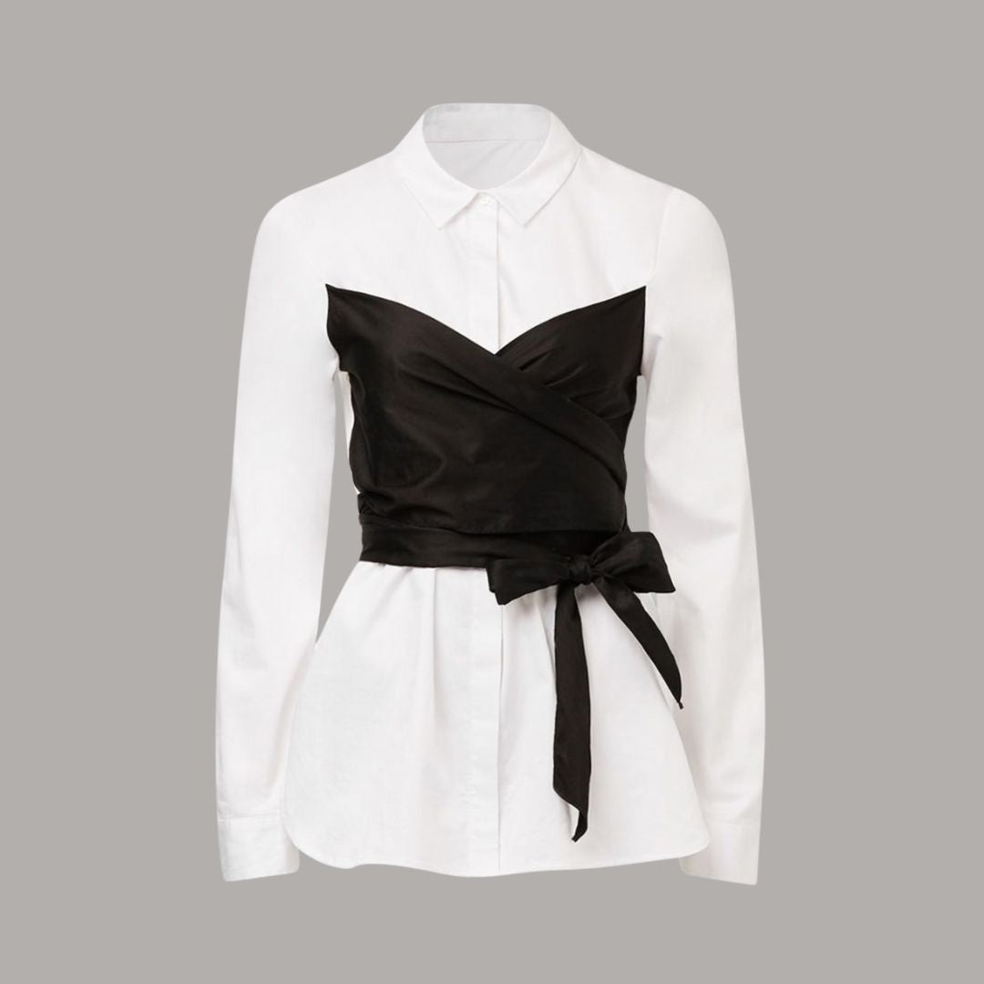 Vit skjorttopp med svart omlottdetalj och knytband i midjan för en modern silhuett