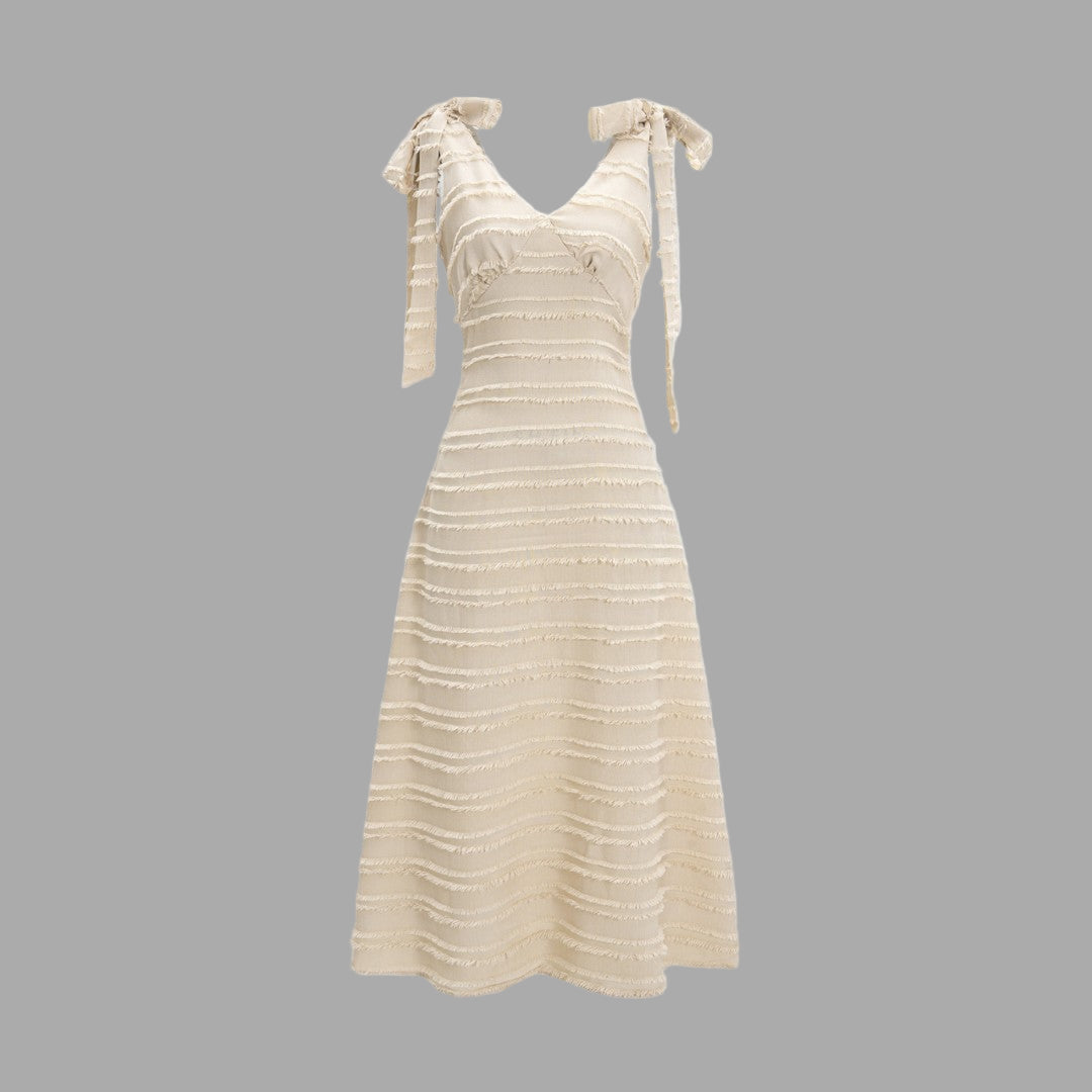 Krämvit midiklänning med knytbara axelband, strukturerad textur och A-linjeform