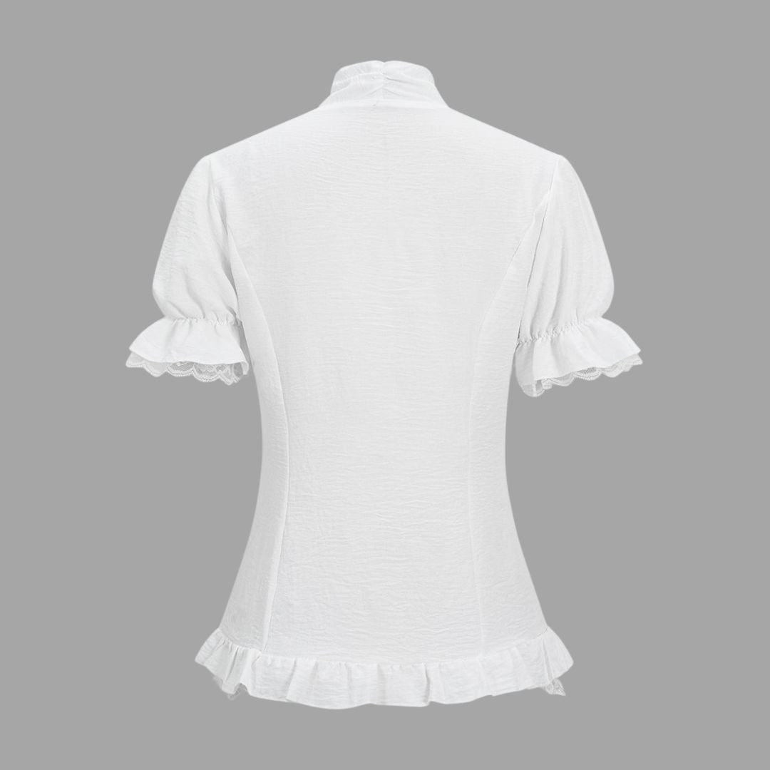 Vit blus med spetskant, korta puffärmar och transparenta knappar
