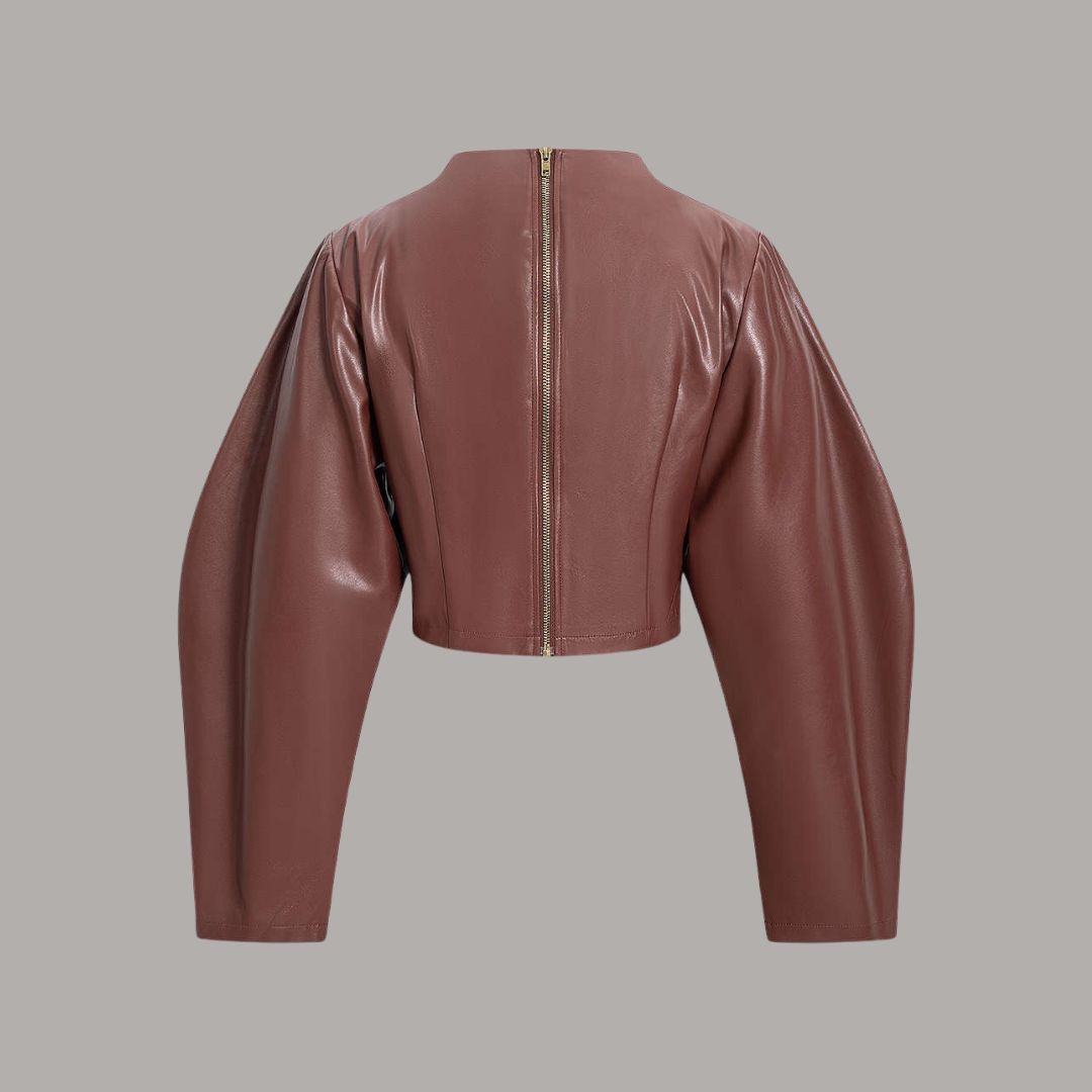 Brun topp i veganskt läder med voluminösa ärmar och skulptural silhuett