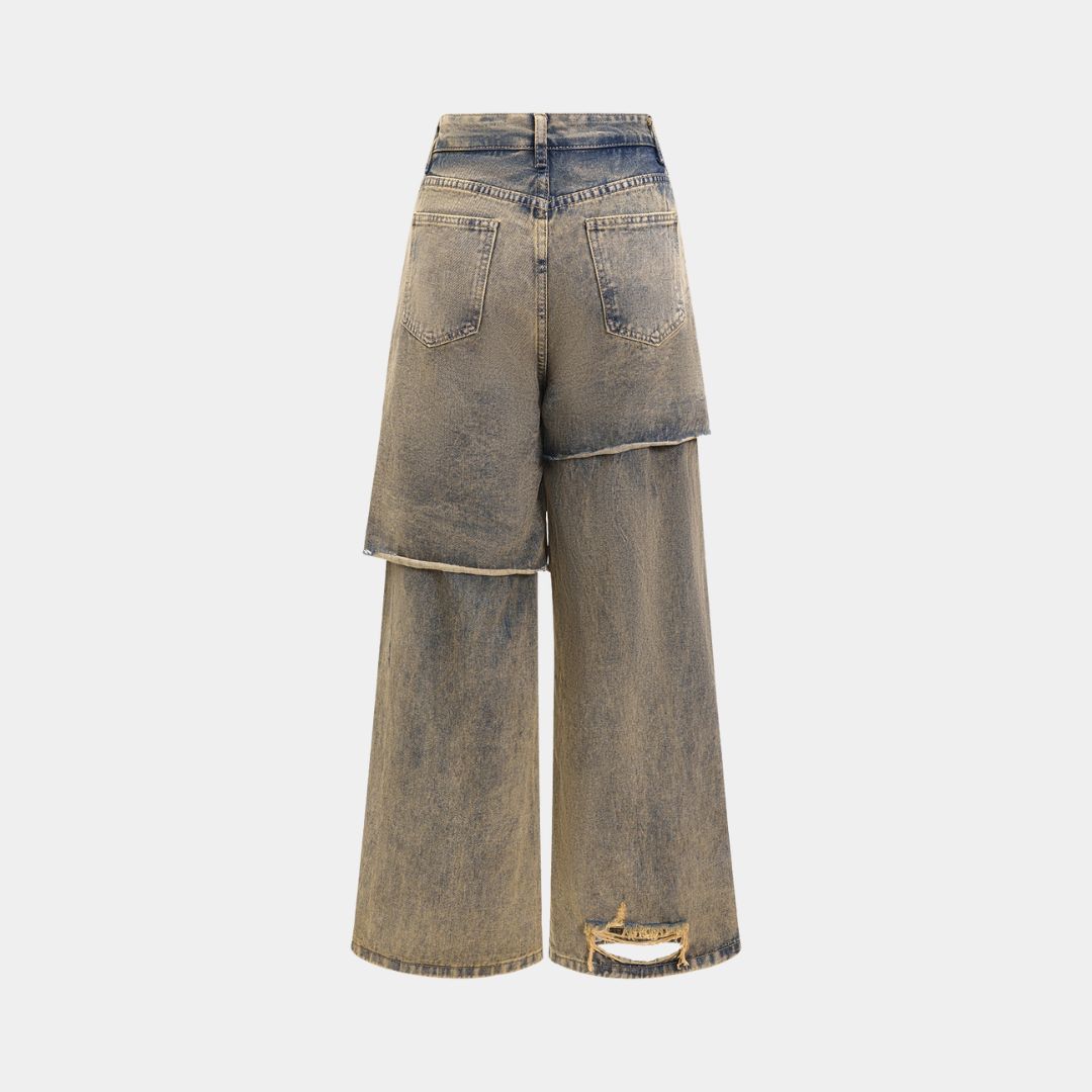 Distressed denimjeans med asymmetriskt shortsöverlägg, rå tvätt och överdrivna slitningar i kraftig bomullsblandning