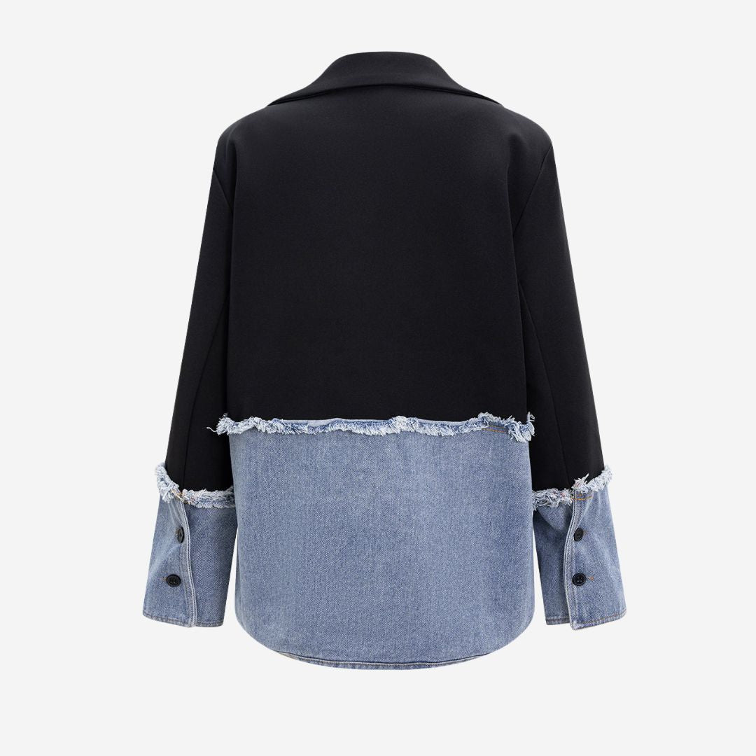 Svart kavajjacka med kontrasterande denimdetaljer och råa kanter i modern tvåtonad design
