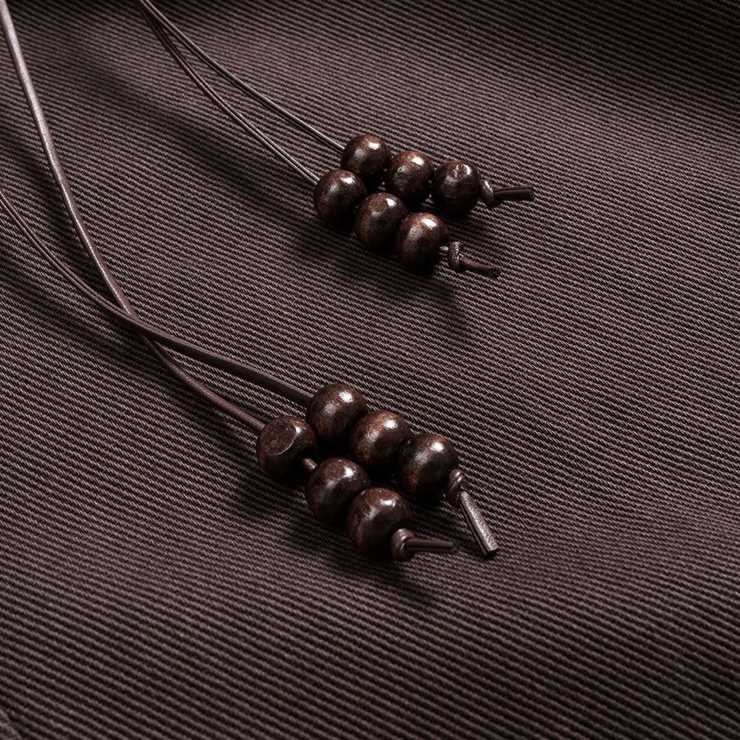 Kaffebruna utsvängda denimbyxor med knytband, träpärlor och flätad bältdetalj i midjan