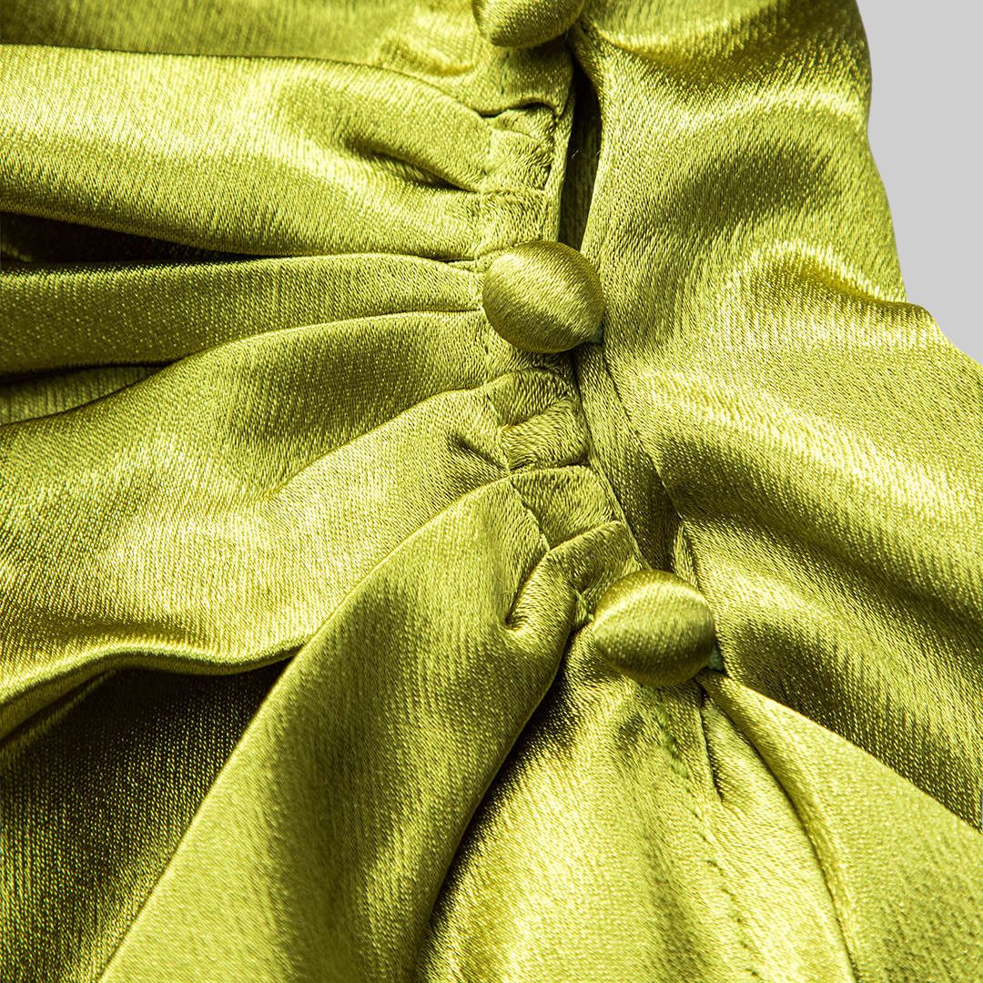 Limegrön figurnära glänsande satintopp med omlottkrage och drapering samt långa ärmar