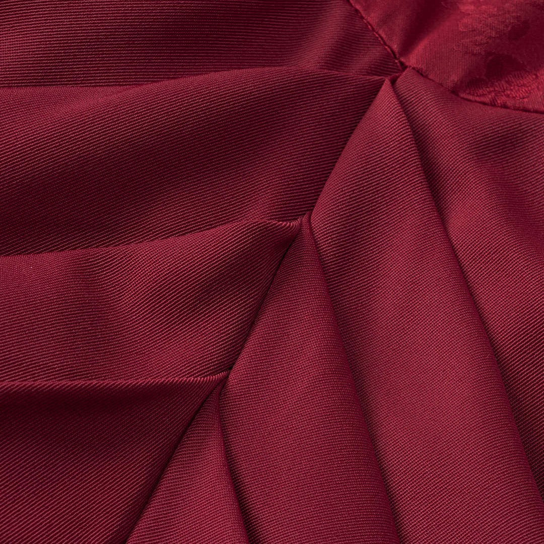 Vinröd satinklänning med korsettliv och draperad kjol