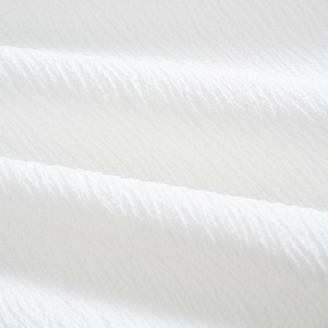 Vit tunikablus i krinklat tyg med knytmidja, ståkrage och långa ärmar