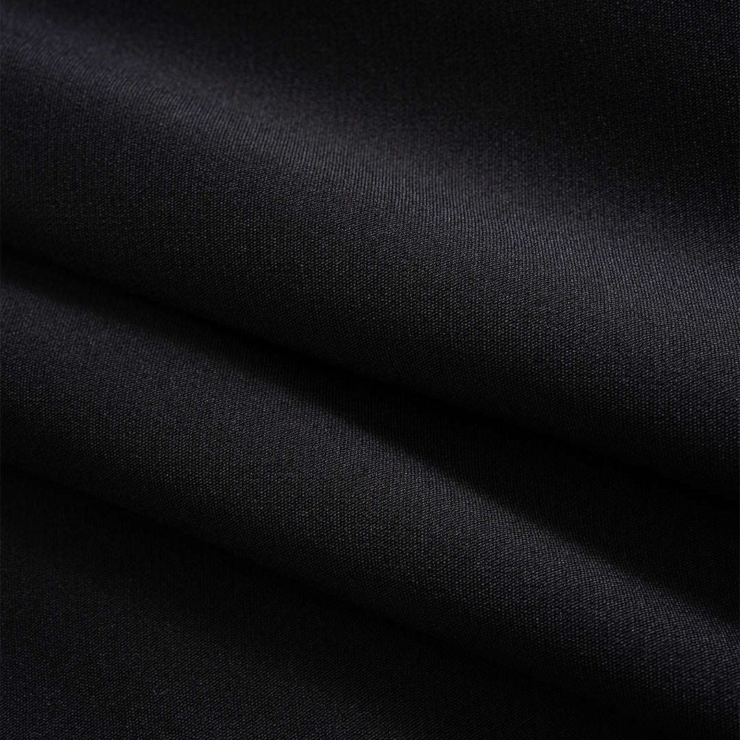 Svart kavajjacka med kontrasterande denimdetaljer och råa kanter i modern tvåtonad design