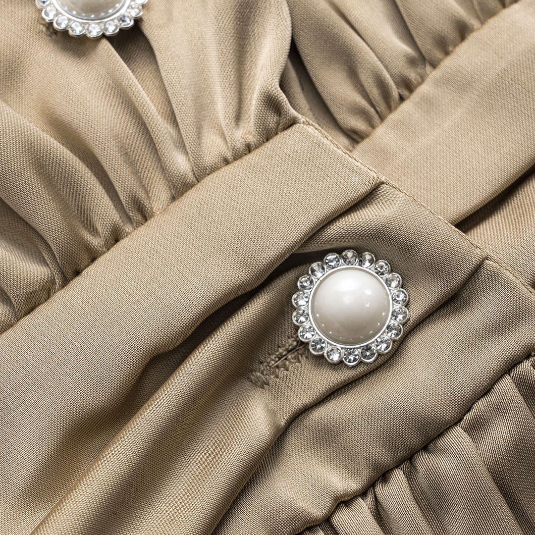 khakifärgad satintopp med plisserade detaljer och pärlknappar