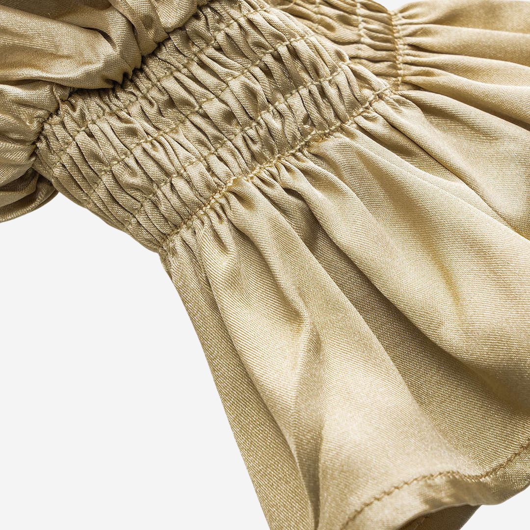 Voluminös satinblus med romantiska volangdetaljer, knytband framtill och smockade ärmslut för en sofistikerad touch