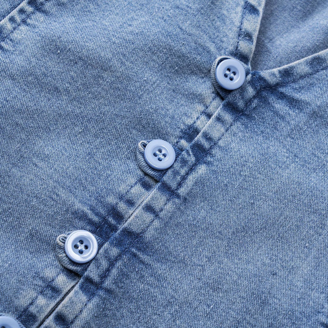 Ärmlös denimväst med snörningsdetaljer och knappar framtill