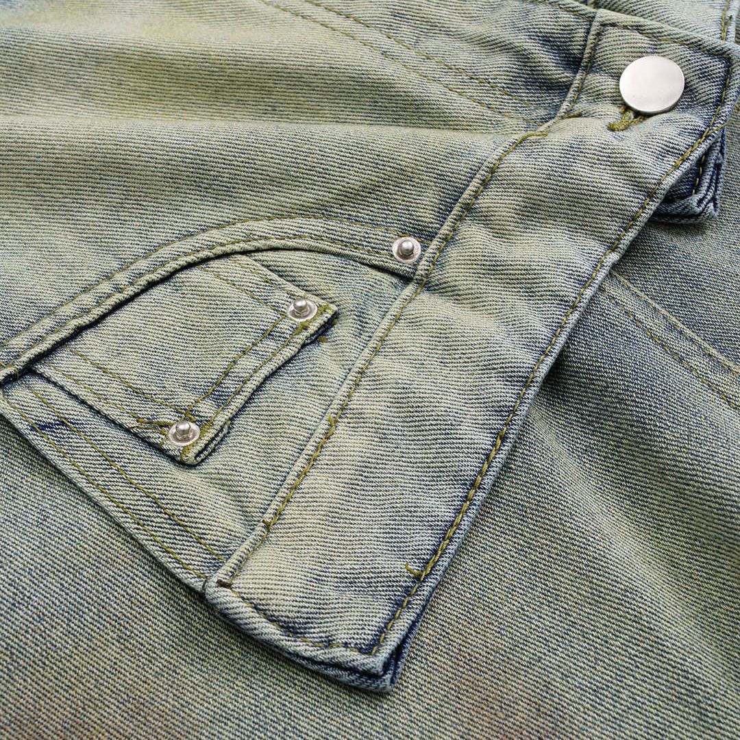 Asymmetriska denimjeans med omlottdesign, blekt färgövergång och vid passform i kraftig bomullsblandning