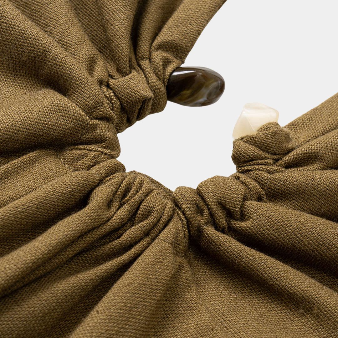 Ärmlös brun midiklänning i twill med halterneck, figurnära passform och dekorativa stendetaljer