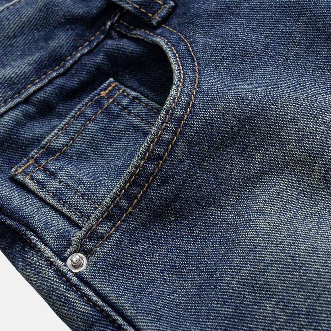 Mörkblå denimbyxa med markerad midja, kjol-liknande överdel och utställda ben