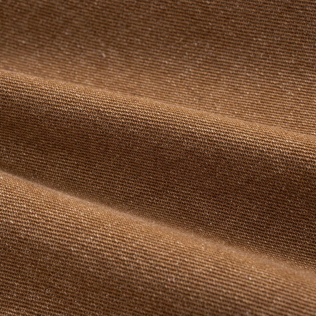 Bruna bomullsbyxor i denim med markerad höftvolym, formsydd midja och justerbara benslut med metallspännen