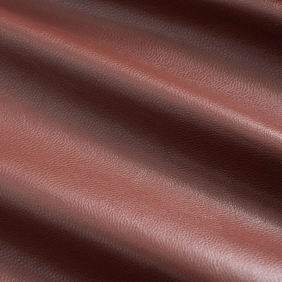 Brun topp i veganskt läder med voluminösa ärmar och skulptural silhuett