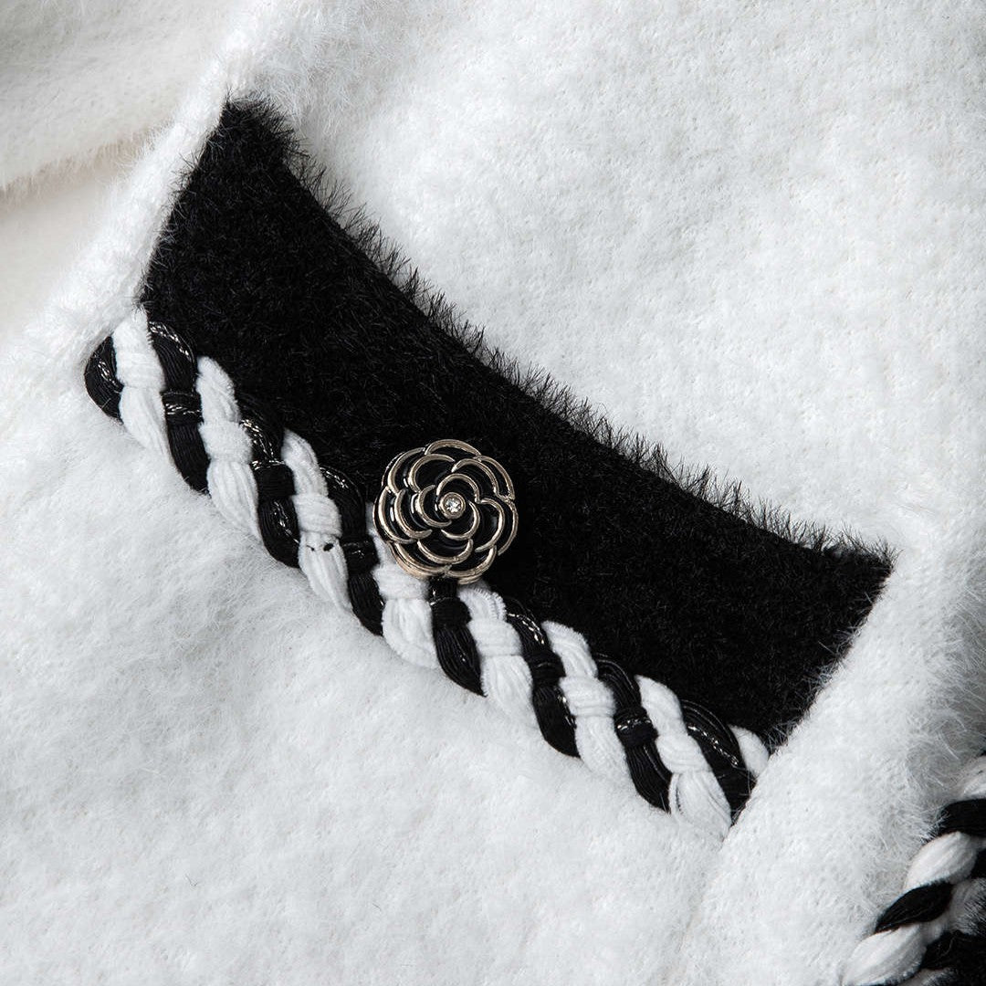 Svartvit stickad kofta med dekorativa knappar och fyrfickdesign