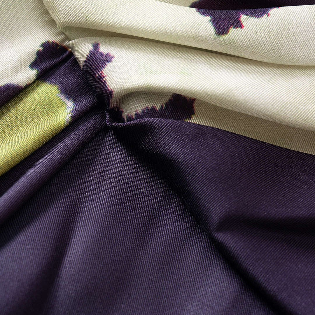 Midiklänning i mönstrad satin med draperad omlottfront, ärmlös design och figurnära siluett