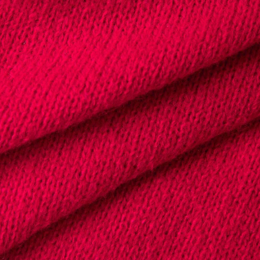 Röd stickad kofta med knappslå och långa ärmar med fuskpälsdetalj