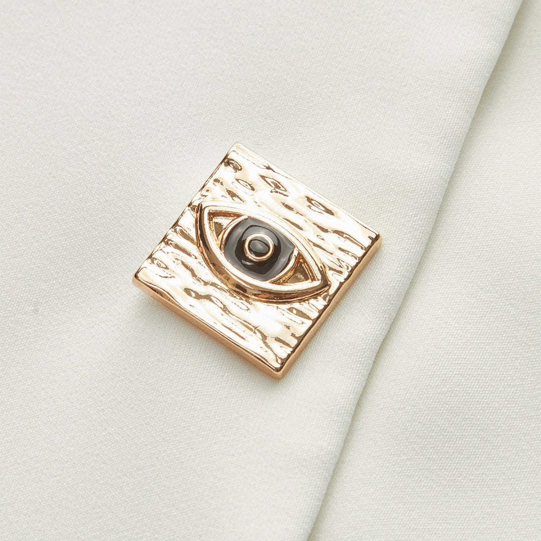 Ärmlös vit väst med asymmetrisk fåll och dekorativa guldknappar