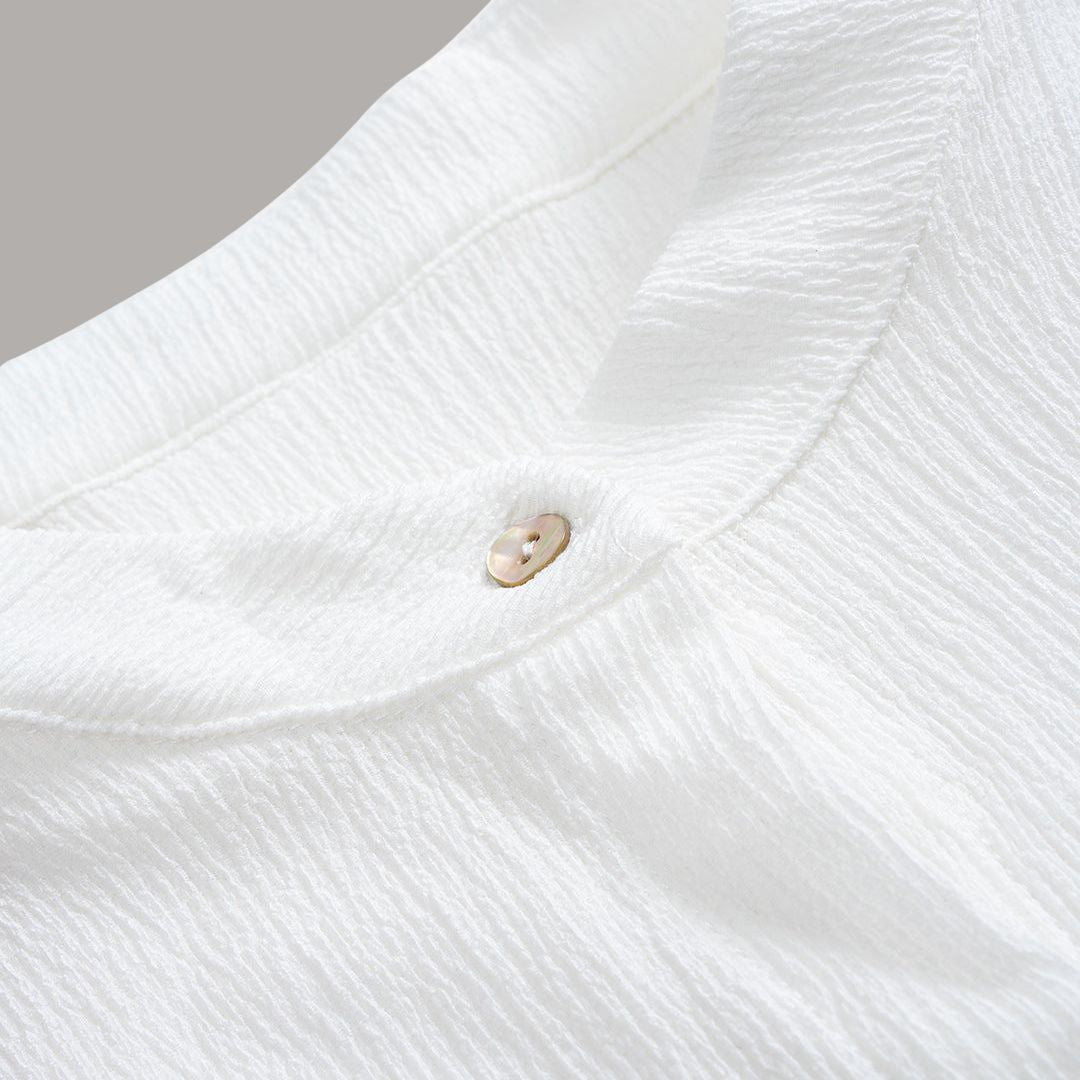 Vit tunikablus i krinklat tyg med knytmidja, ståkrage och långa ärmar