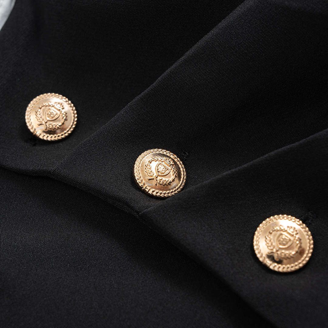 Svartvit asymmetrisk skjorttopp med draperad front och dekorativa guldknappar