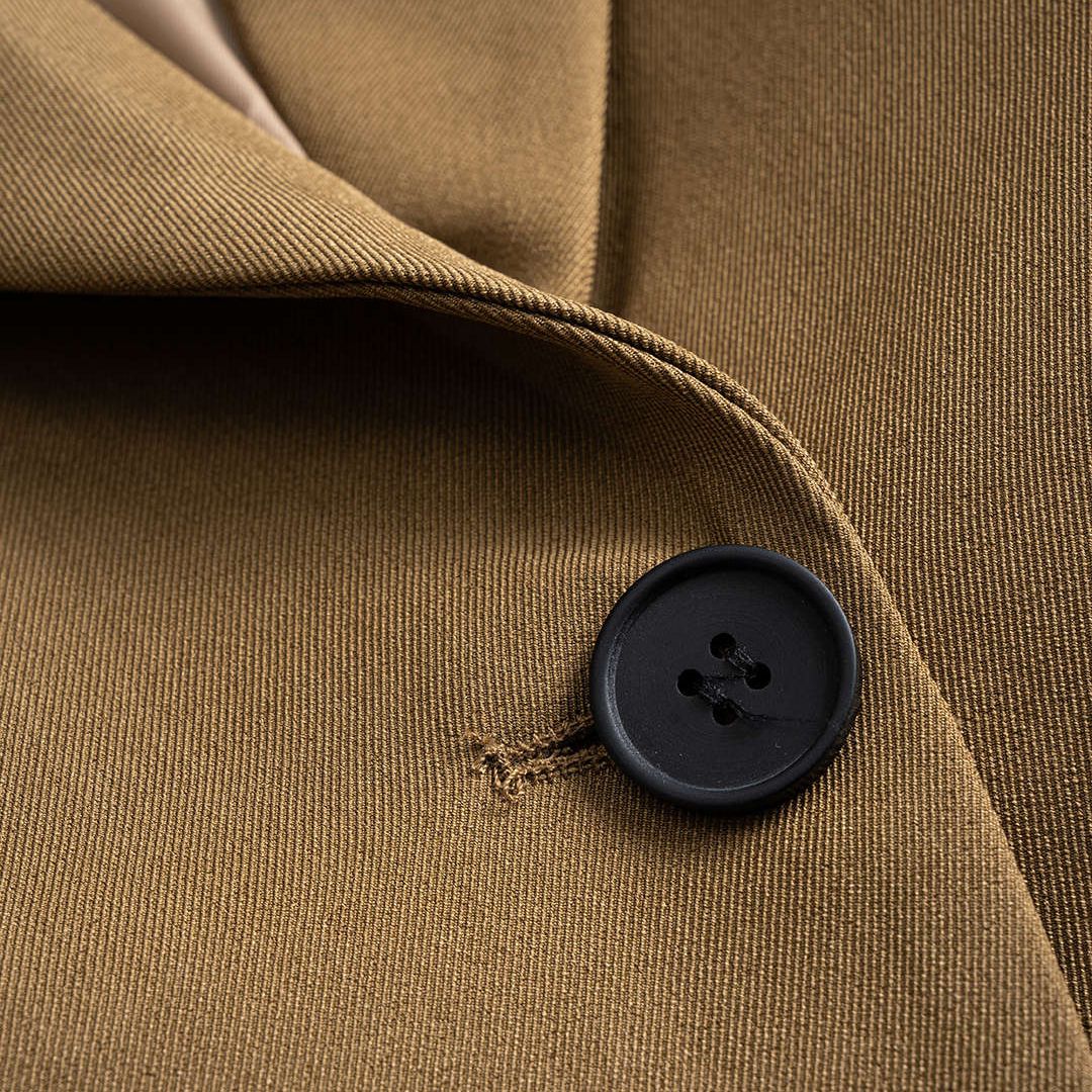 Brun figursydd kavaj med snörning i sidorna och spetsiga slag