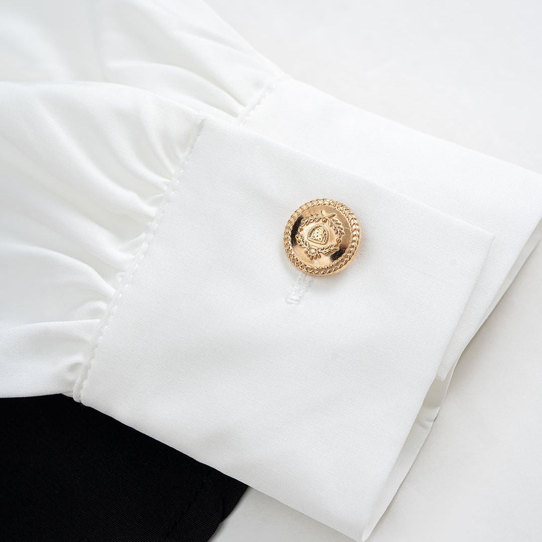 Svartvit asymmetrisk skjorttopp med draperad front och dekorativa guldknappar