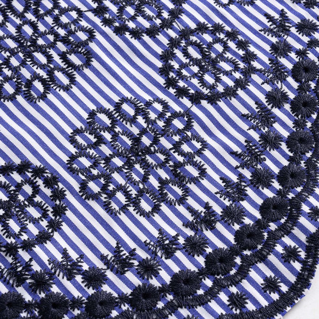 Blårandig topp med knytning framtill och broderade detaljer i fållen