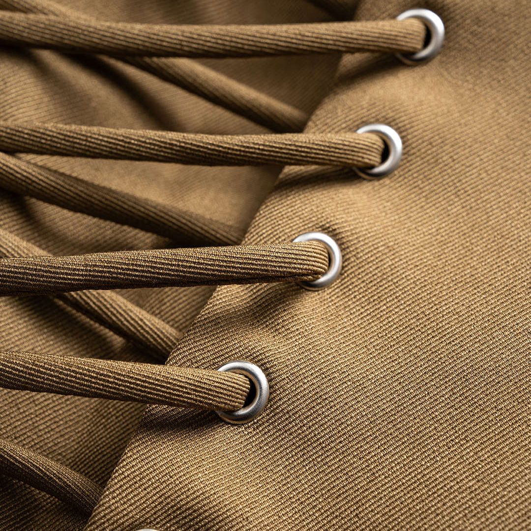 Brun figursydd kavaj med snörning i sidorna och spetsiga slag